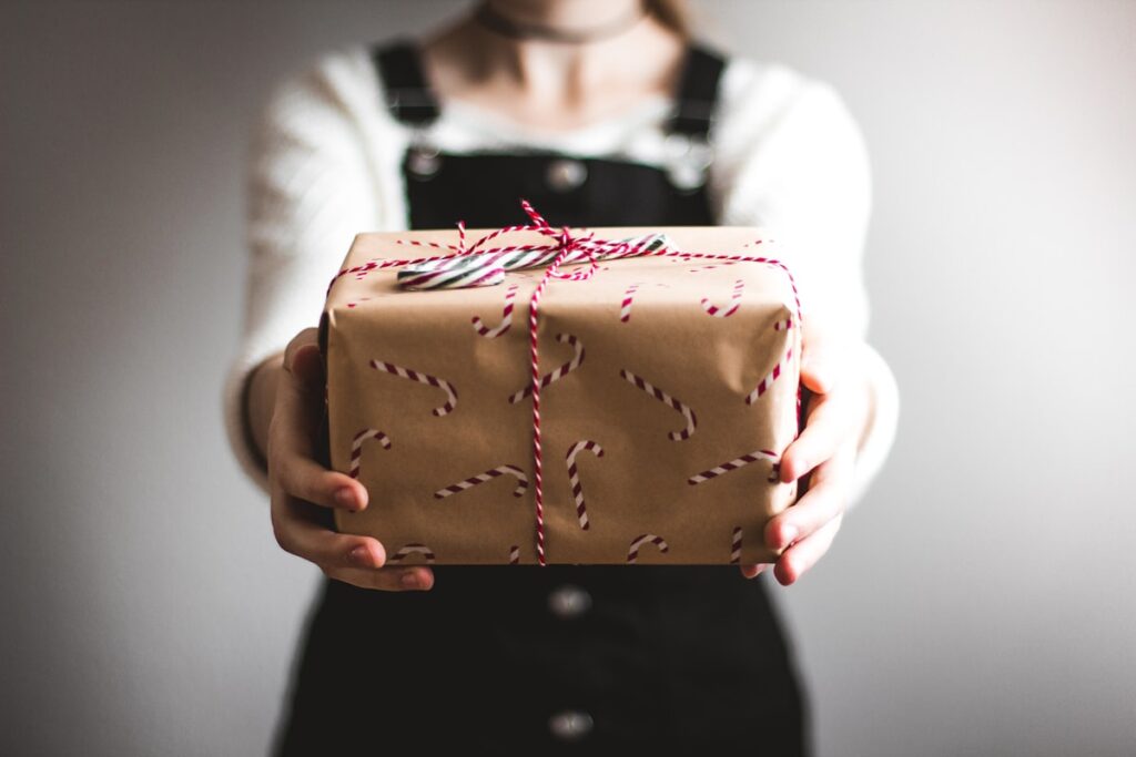 Person presenting a wrapped gift