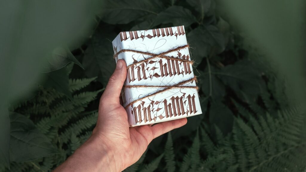 Hand holding a wrapped gift box with twine