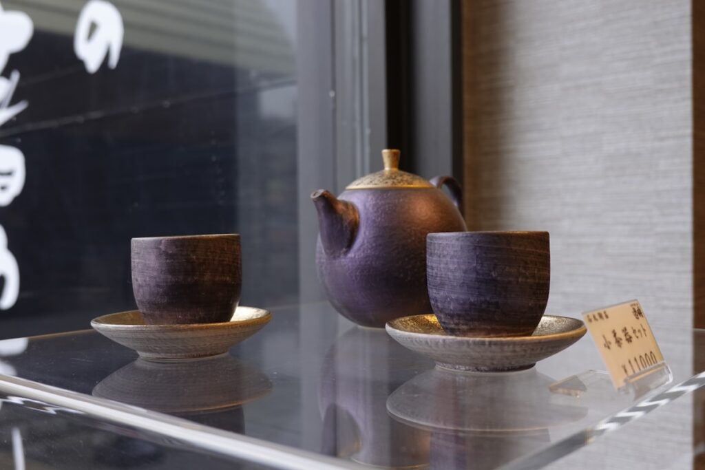 Ceramic tea pot and cups on a shelf