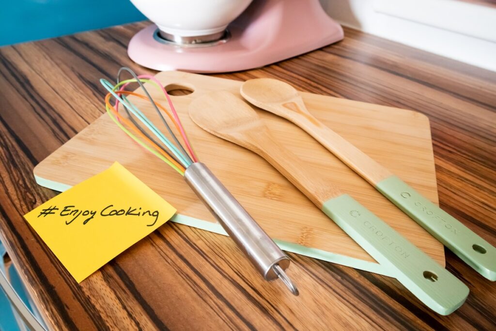 Cutting board topped with kitchen utensils